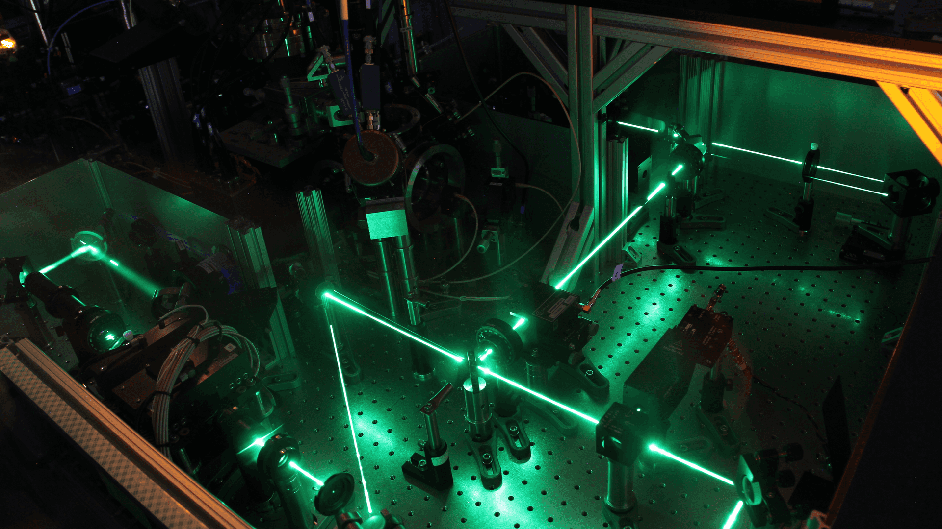 a photo of an optics bench with green laser beams
